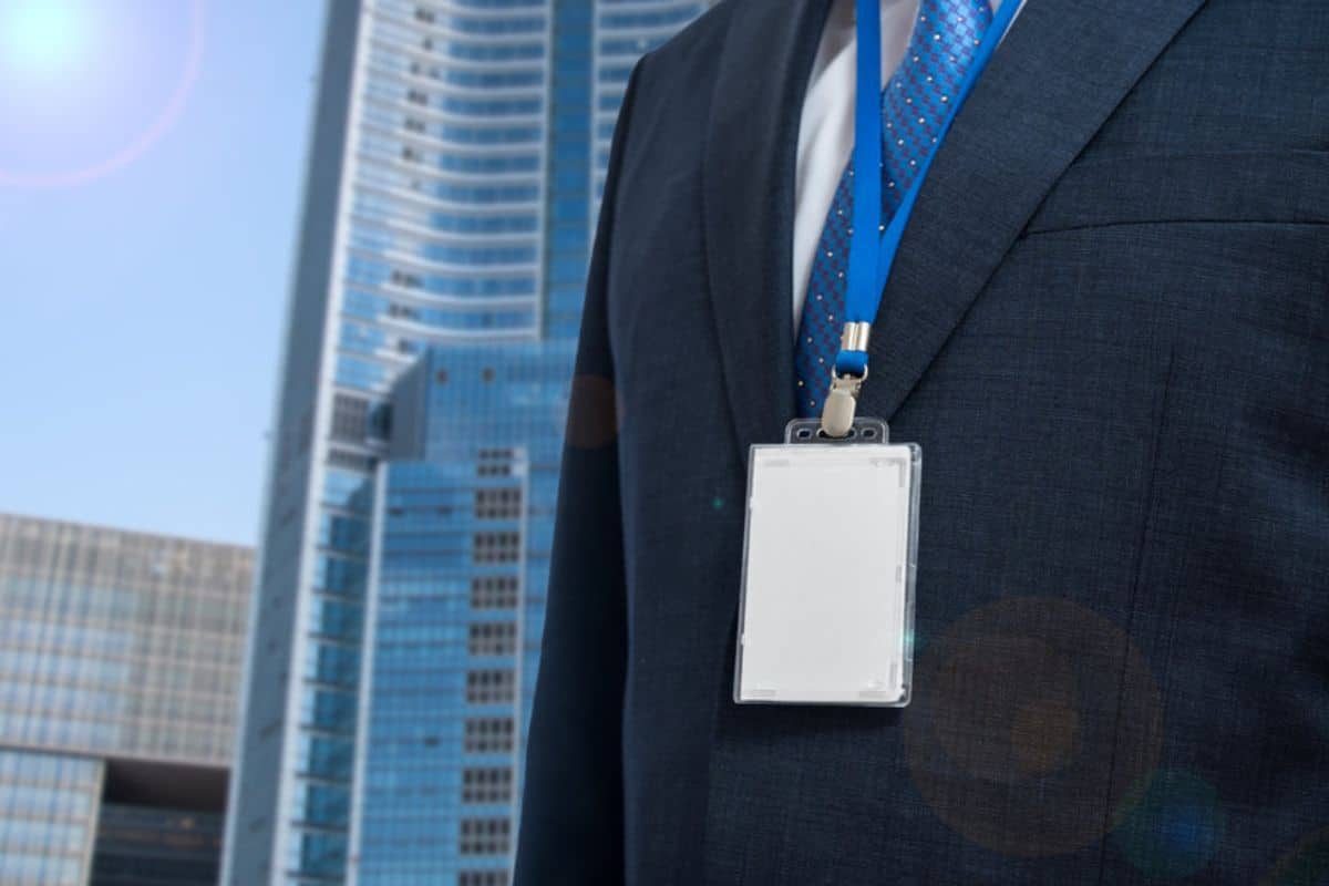 Homme en costume portant un badge vierge